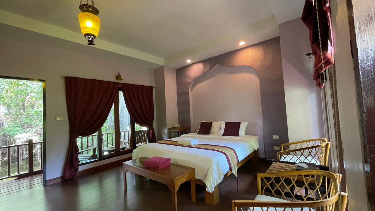 Interior of a Thai-style villa at Baan Thai House with an arched headboard niche