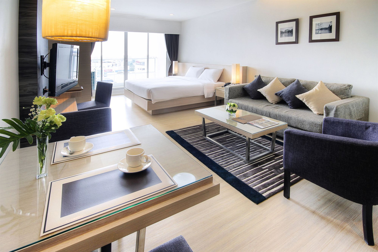 One Bedroom Suite living area with sofa and balcony city view at Classic Kameo Ayutthaya