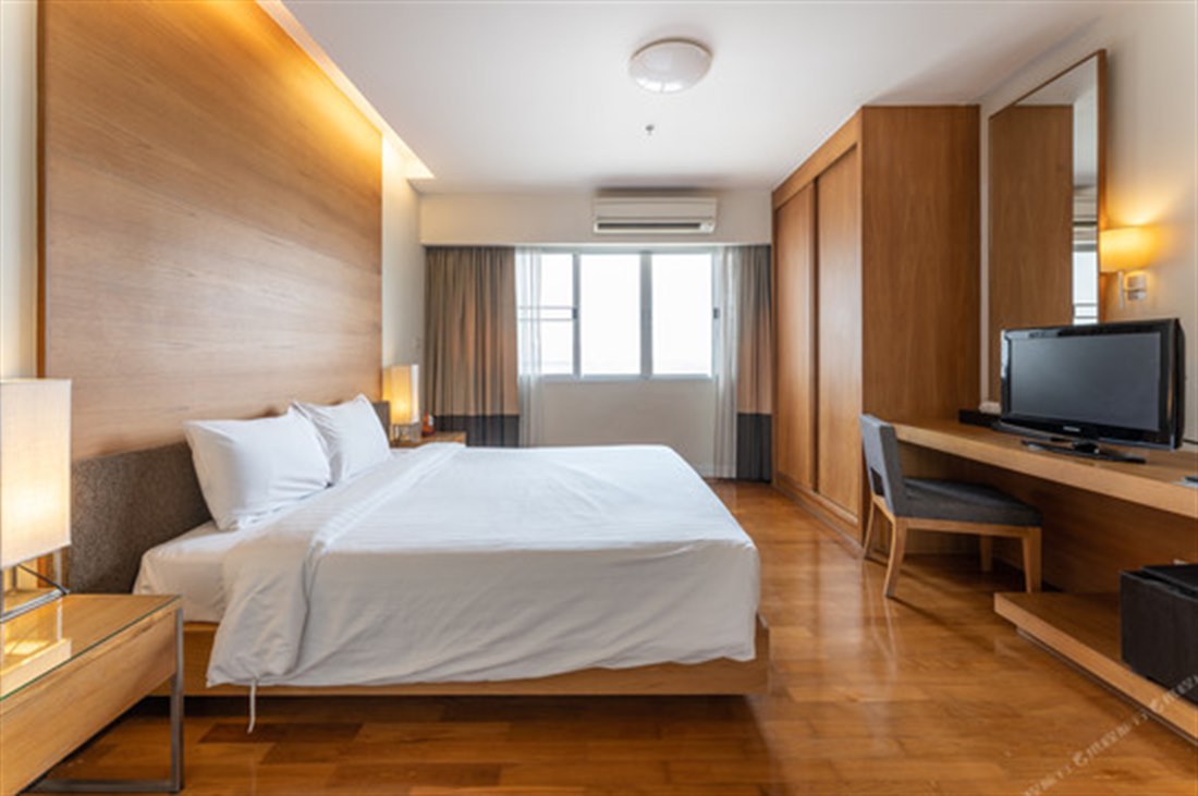 Bedroom inside a suite at Kantary Hotel Ayutthaya with parquet floors and city views
