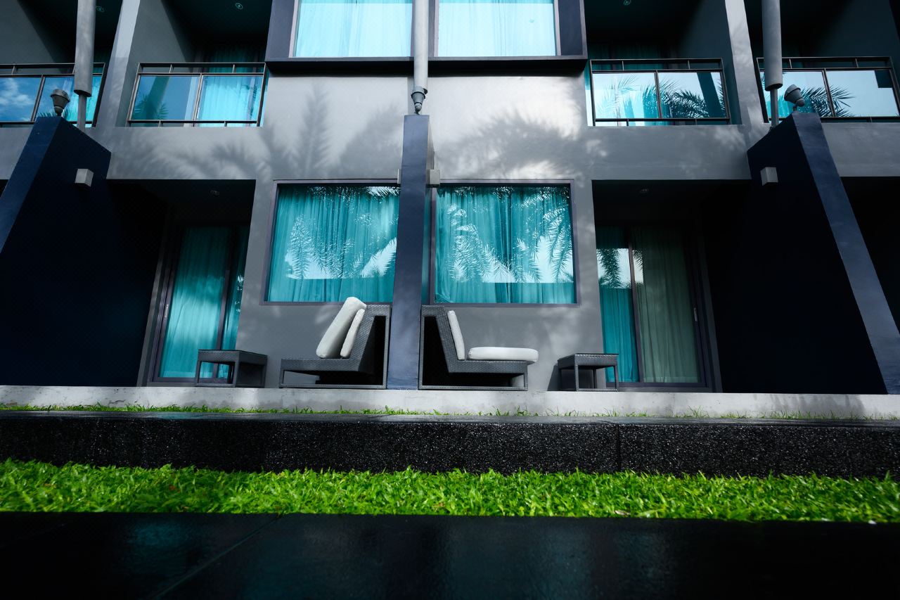 Guest-room terrace with outdoor chairs and mint-green curtains