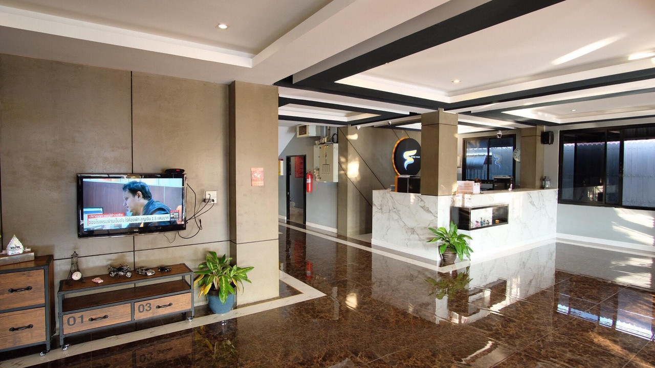 Lobby with polished stone floor and a reception counter bearing the S logo