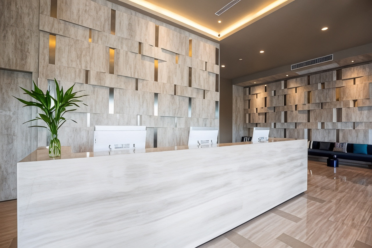 Lobby with a marble reception desk and textured stone feature wall