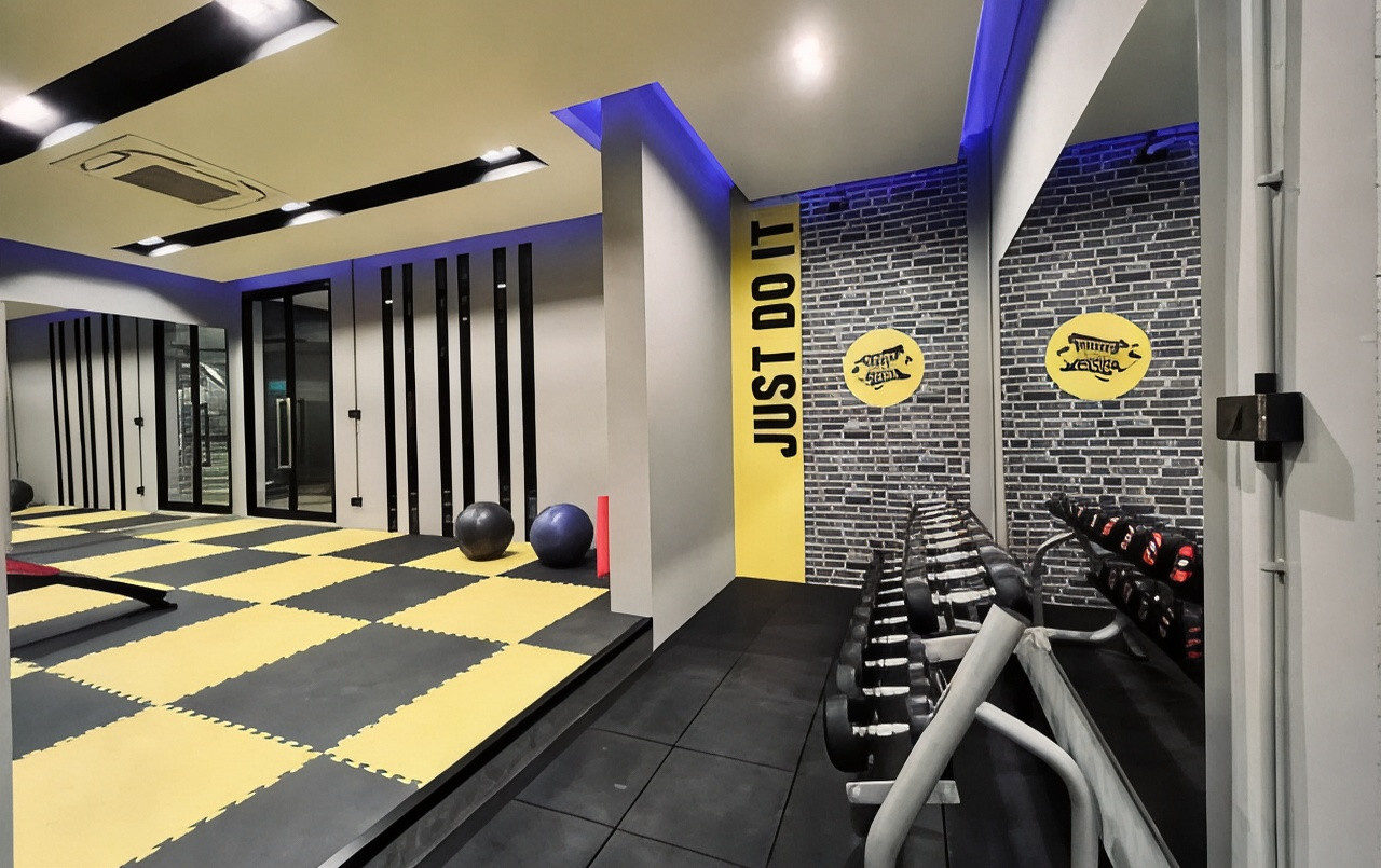 Gym with free weights, padded matting and Buriram club logos on the wall
