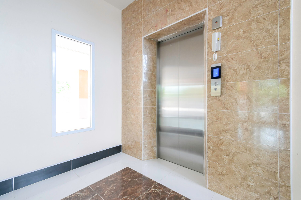 Marble-tiled elevator lobby inside The Wish Hotel
