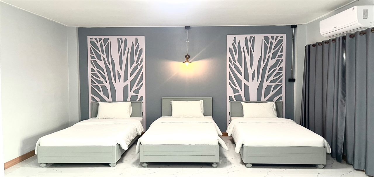 ห้องพักแบบ Triple เตียงเดี่ยว 3 เตียง ผนังลายต้นไม้ที่ Chainat Grand Hotel