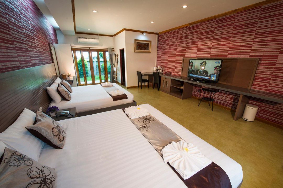 Guestroom interior at 111 Resort & Spa with twin beds and red wood-pattern wall