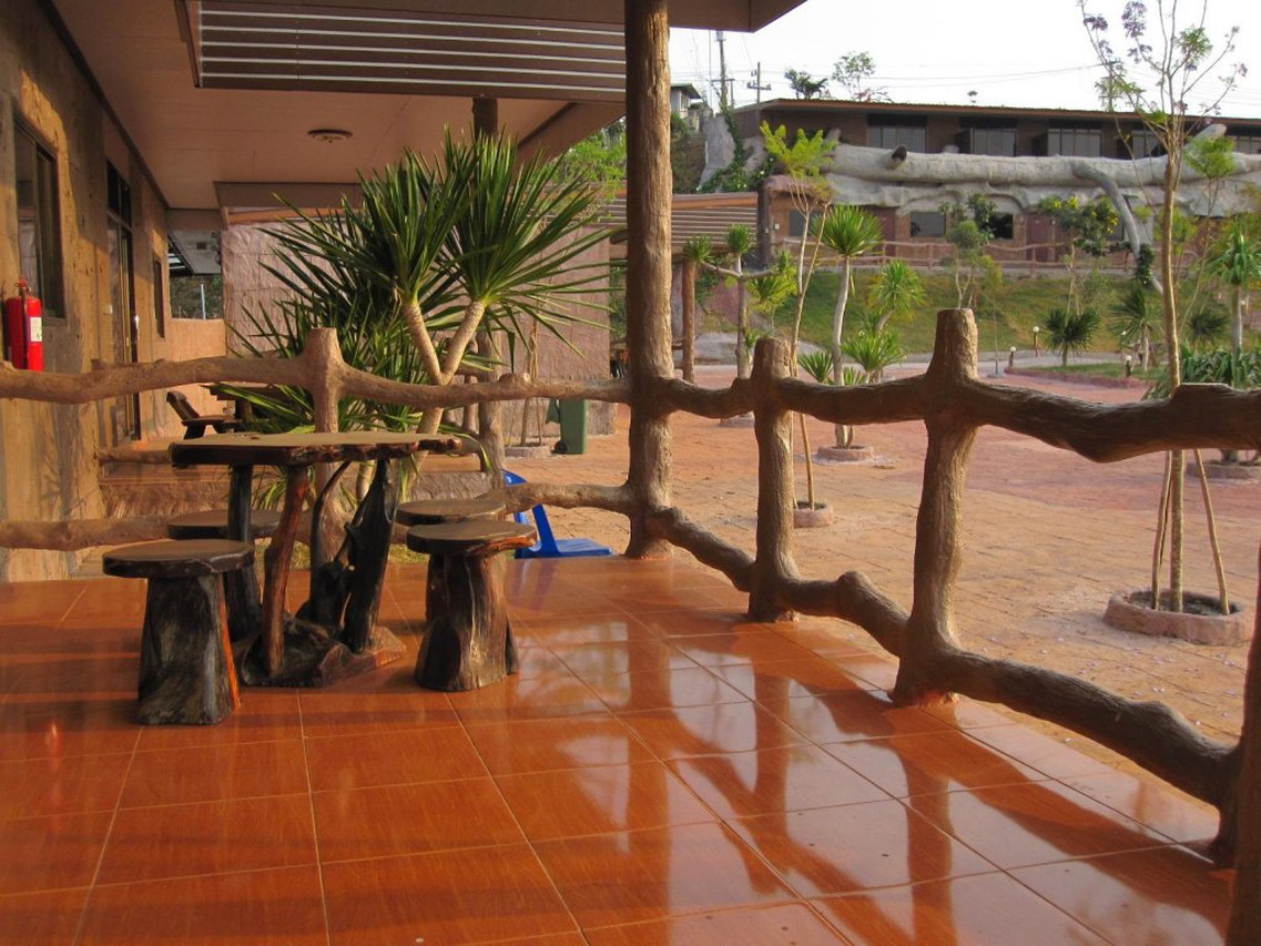ลานนั่งเล่นโต๊ะไม้สไตล์ rustic หน้าห้องพักริมสวน