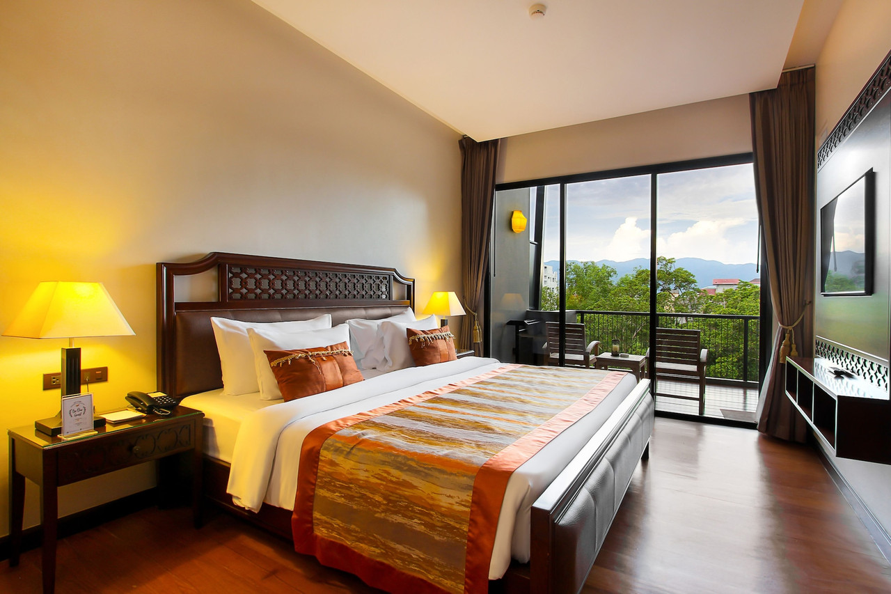 Deluxe room with a king bed and a private balcony overlooking the river and hills