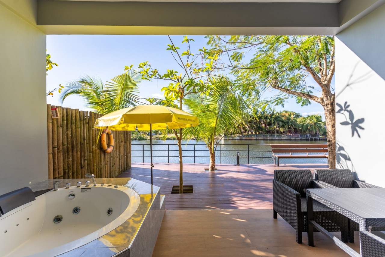 Suite with an outdoor Jacuzzi on a wooden deck beside the river