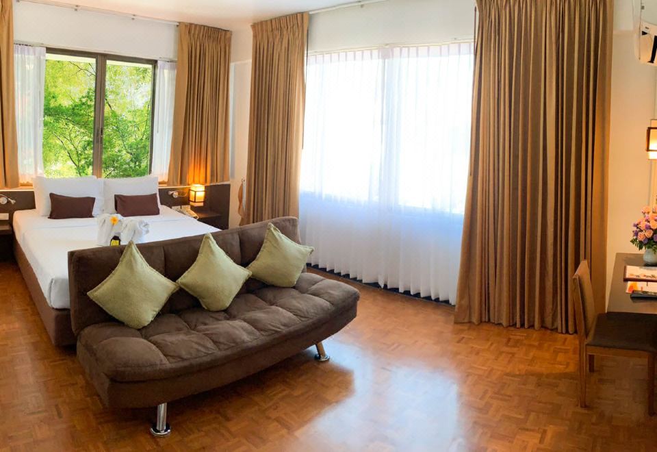 ห้อง Deluxe โรงแรม Hotel M พร้อมโซฟาและวิวสวน