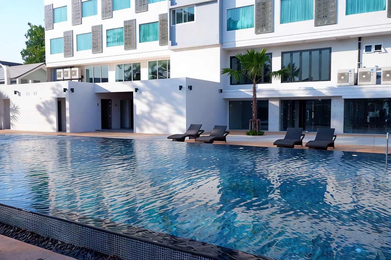 Outdoor pool at Sann Hotel Chiang Rai with sun loungers and a palm tree