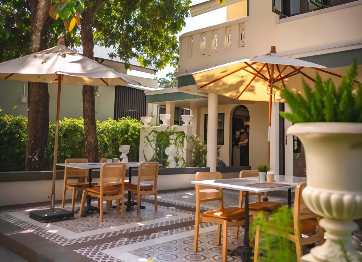 Garden dining terrace with white umbrellas and patterned tile flooring