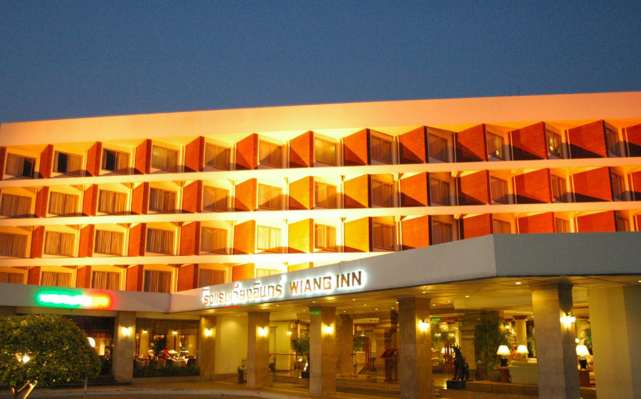 Wiang Inn Hotel Chiang Rai lit up at night with the hotel sign