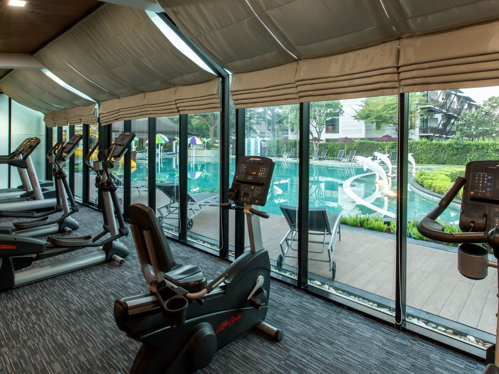 Poolside fitness room overlooking the outdoor pool and waterslide