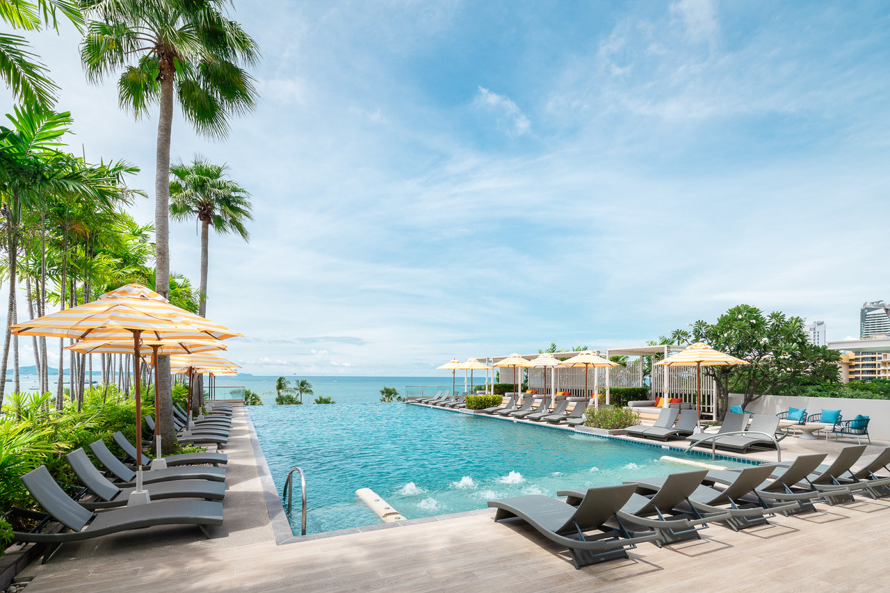 Sea-facing infinity pool with the water edge meeting Pattaya Bay and the city skyline