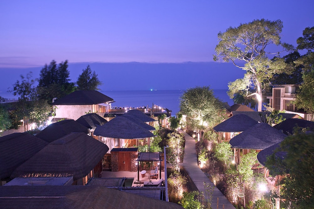 Aerial view of thatched villas and the private beach at Bang Sare