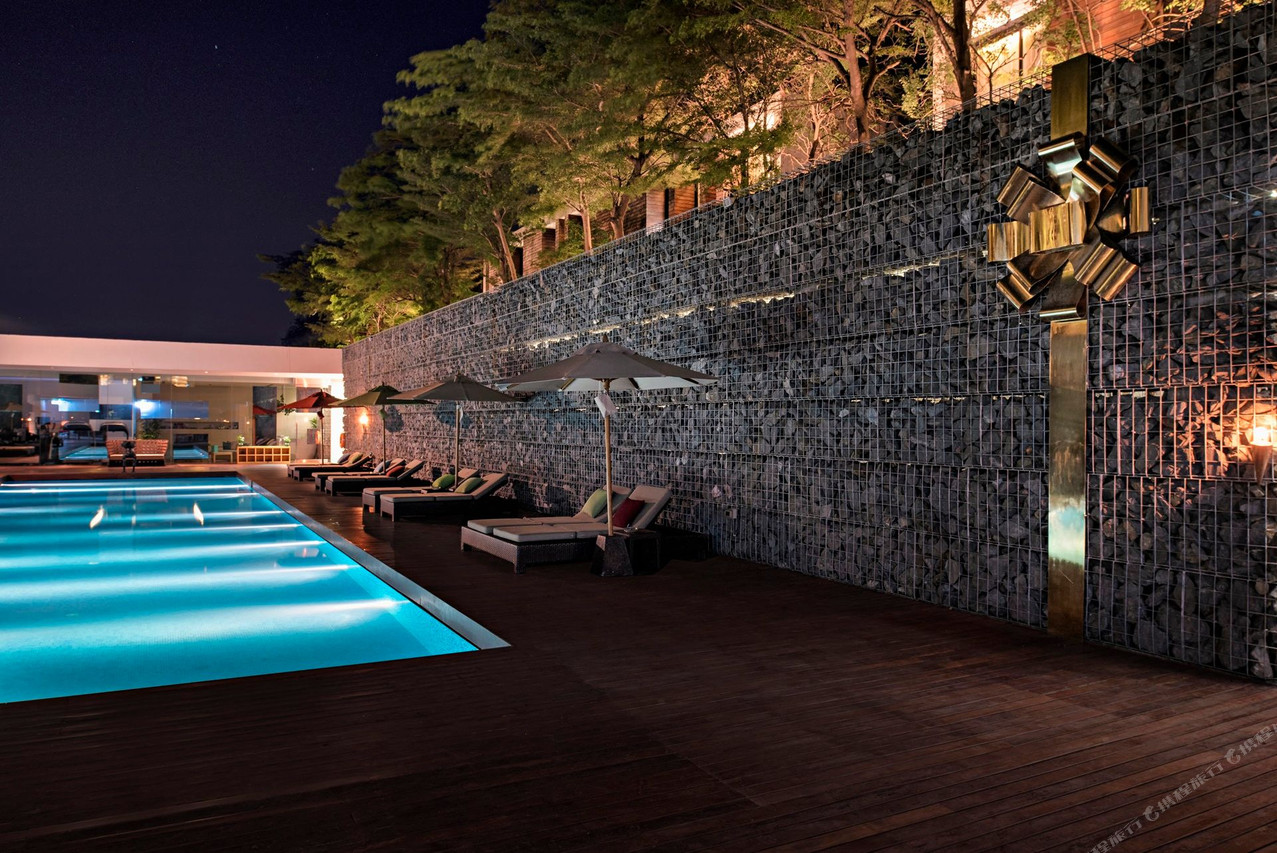 กำแพงหิน gabion กลางรีสอร์ตกับสระว่ายน้ำยามค่ำที่ SO/ Sofitel Hua Hin