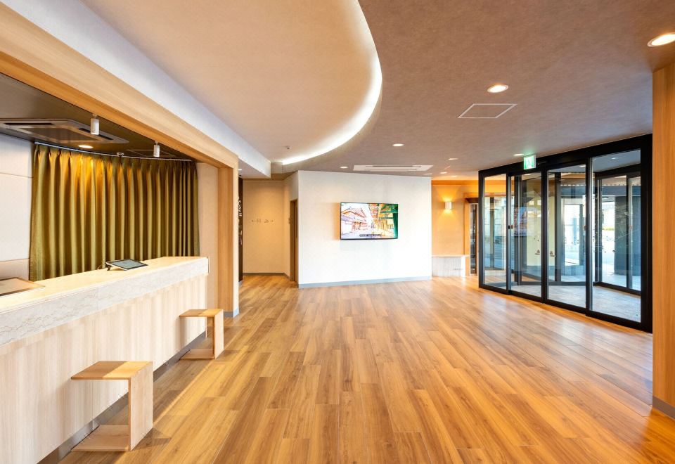 Warm wood-toned lobby and check-in counter at EN HOTEL Ise