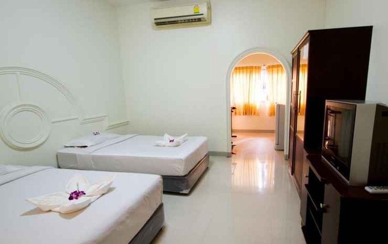 ห้องพักเตียงคู่ของ A.P. Garden Hotel หัวเตียงปูนปั้นวงกลม โทนขาวสว่าง