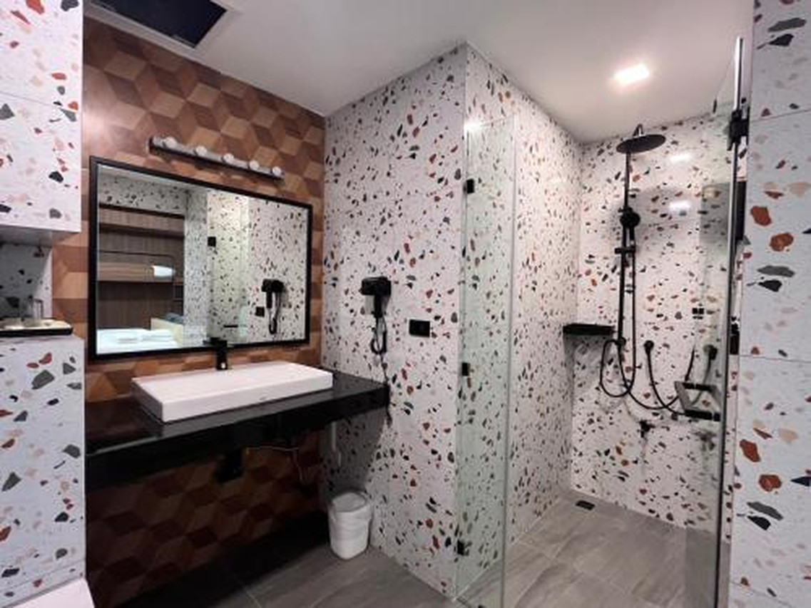 J2 Hotel terrazzo bathroom with a rain shower behind clear glass