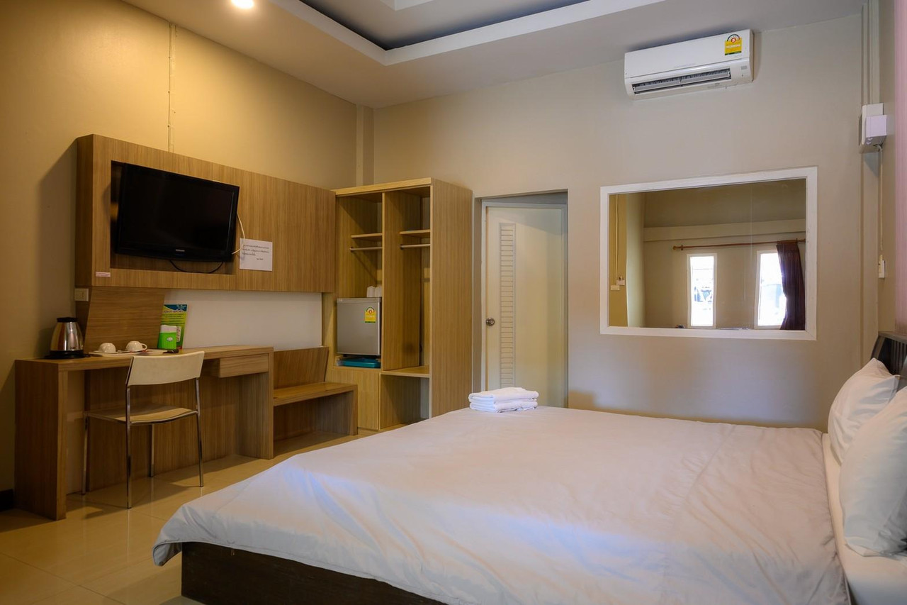 ห้องพักของ The Resort Kamphaengphet เตียงคิงพร้อมทีวี แอร์ และช่องกระจกเปิดสู่ห้องน้ำ
