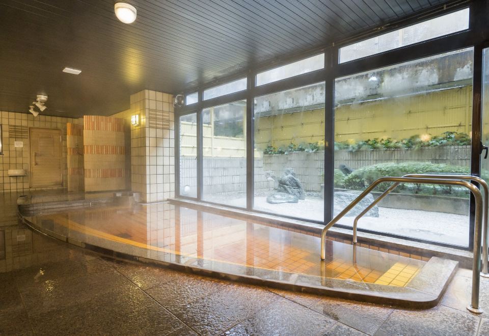 Shiratori natural hot spring communal onsen bath at Hakuchoro Hotel, Kanazawa, with garden view