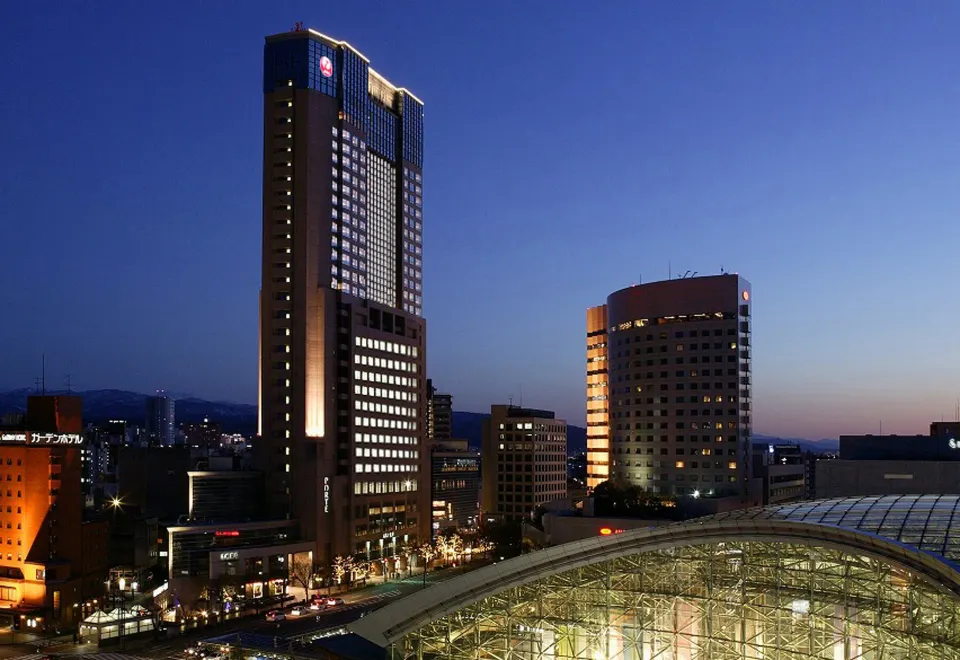 Hotel Nikko Kanazawa tower rising above the Kanazawa cityscape with mountains in the background