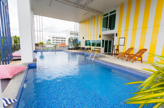Indoor saltwater pool on the 2nd floor with yellow-and-white striped wall at The Bridge Residence Hotel