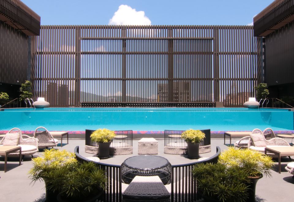 H2O Hotel Kaohsiung rooftop pool with blue water, lounge chairs and city skyline beyond