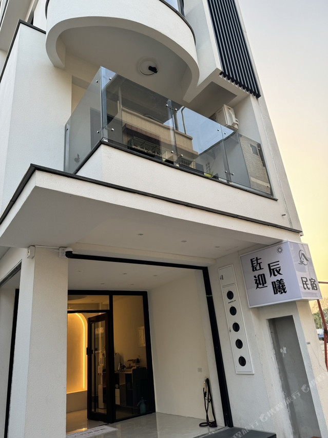 Close-up of B&B entrance with 燕迎晨曦 民宿 sign at golden hour