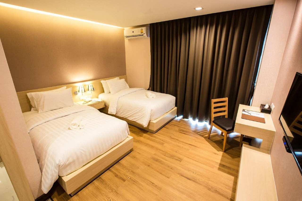 ห้องพักเตียงคู่ L Hotel Khon Kaen โทนไม้อุ่น ผ้าม่านทึบแสง โต๊ะทำงาน