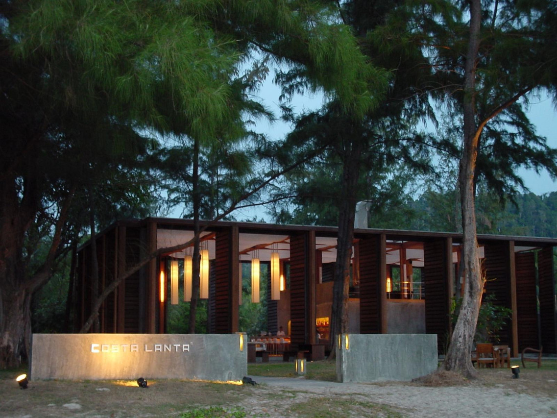 Concrete Costa Lanta entrance sign in front of the open-air restaurant pavilion at dusk