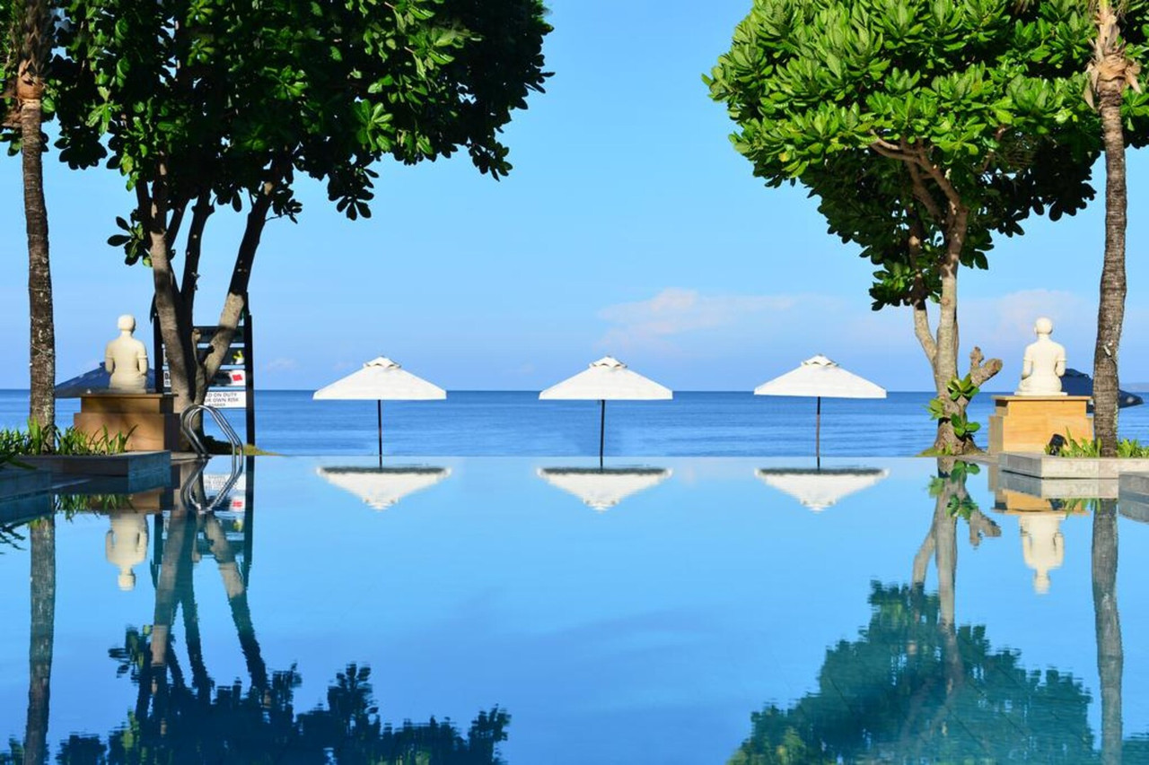 Saltwater infinity pool at Layana Resort facing the Andaman Sea with seated Buddha statues either side