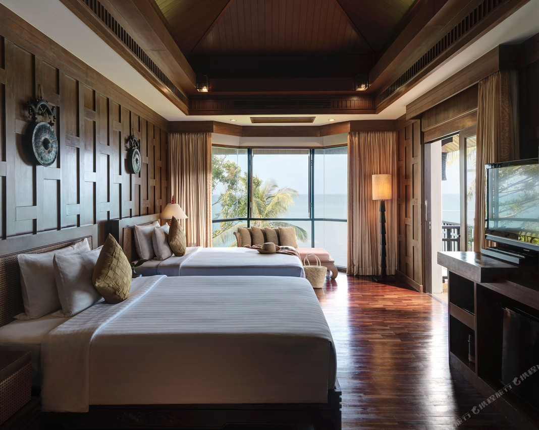 Teak sea-view villa bedroom with large windows facing the Andaman Sea