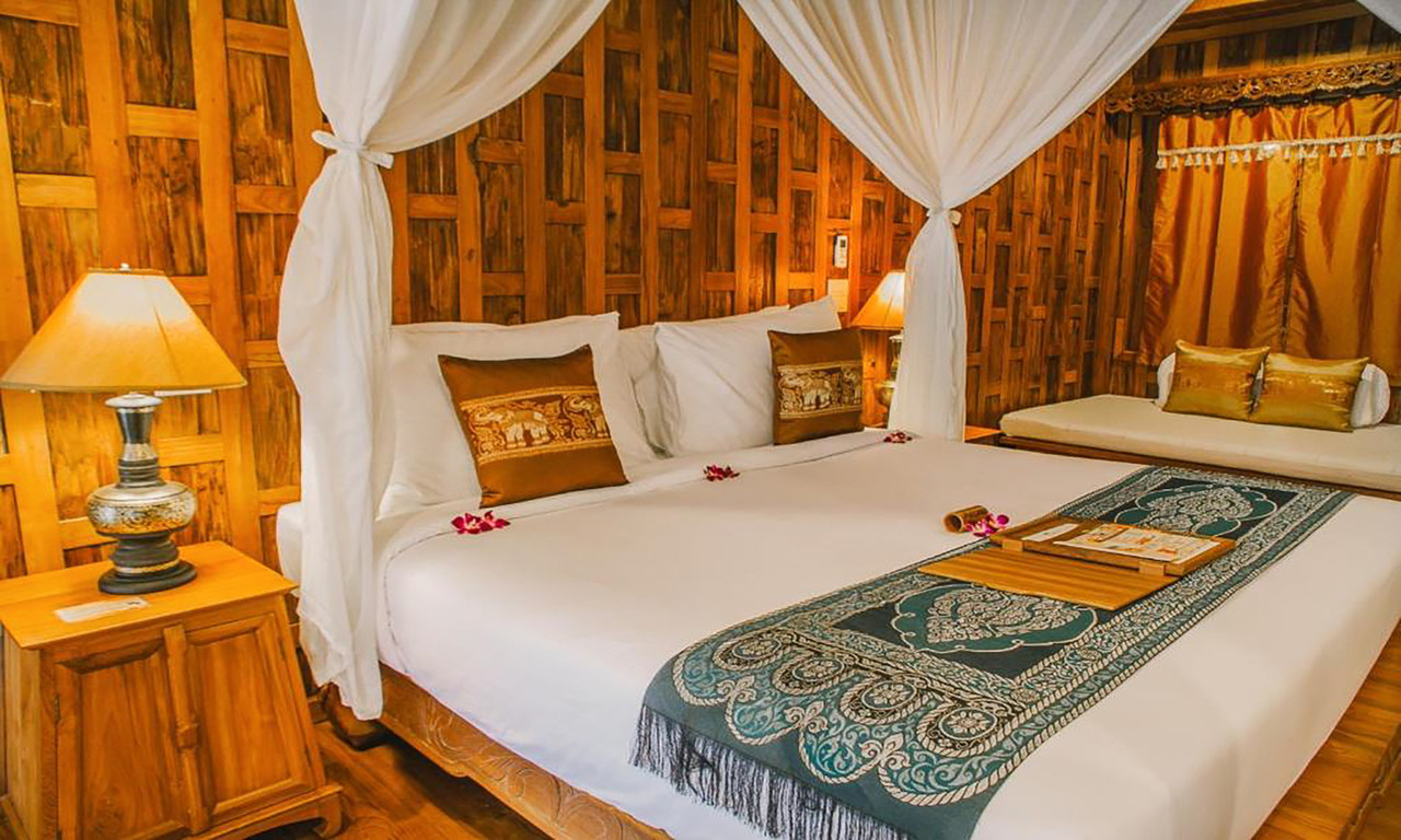 ห้องนอนวิลล่าไม้สักแกะสลัก เตียงมีผ้าม่านคลุมและผ้าไหมไทย Santhiya Koh Phangan