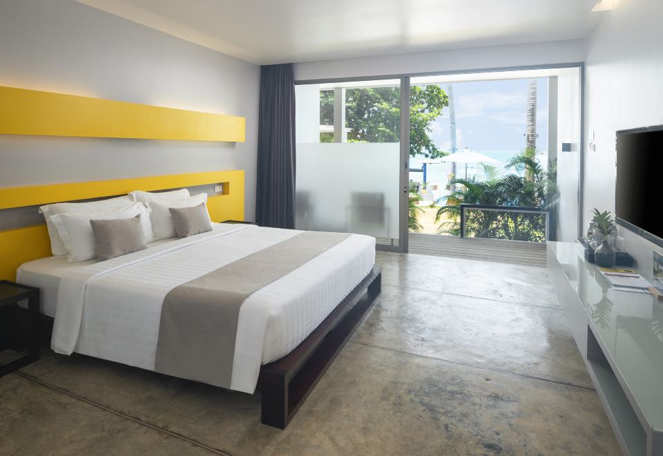 Modern guest room with polished floor, yellow accent headboard and a balcony over the pool and sea