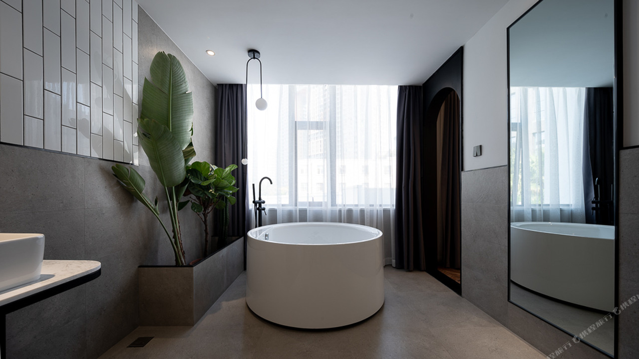 หน้าตึก The Ananas Hotel Green Lake Kunming (昆明翠湖安舍酒店) ยามค่ำ มีต้นไม้เขียวและป้าย Ananas