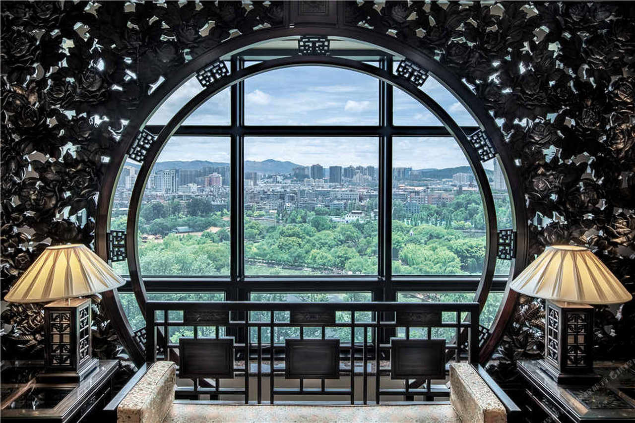 Zhongwei Green Lake Hotel Kunming (昆明中维翠湖宾馆) — วิวมุมสูงยามค่ำเห็นตัวโรงแรมอาบไฟสีทองริมทะเลสาบเฉุยหูกับเส้นขอบฟ้าคุนหมิง