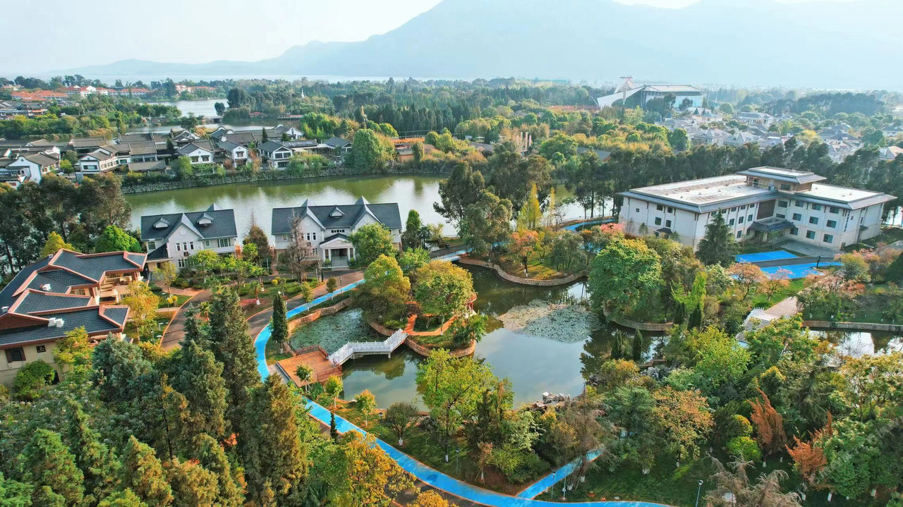 วิวมุมสูงของรีสอร์ตริมทะเลสาบเตียนฉือ มองเห็นน้ำกว้างกับเขาซีซานเป็นฉากหลัง