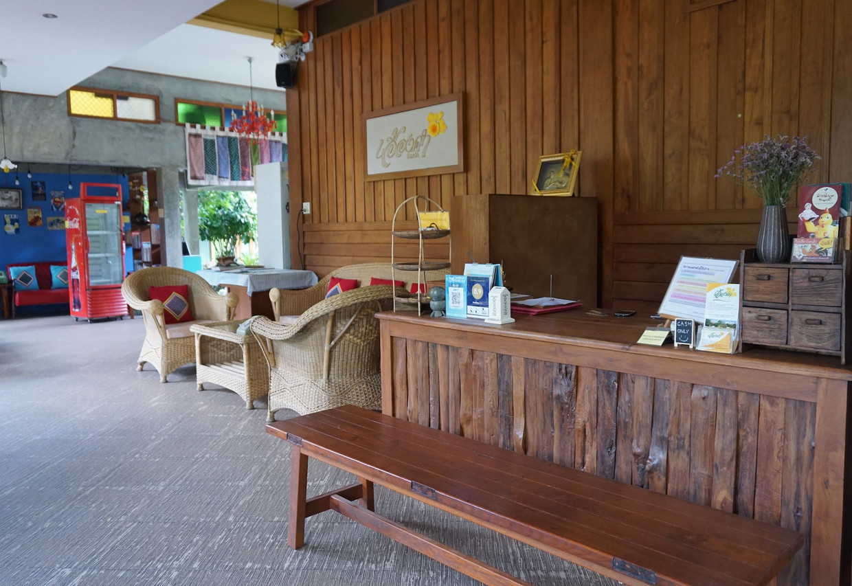Teak reception counter with rattan chairs in a Lanna garden house