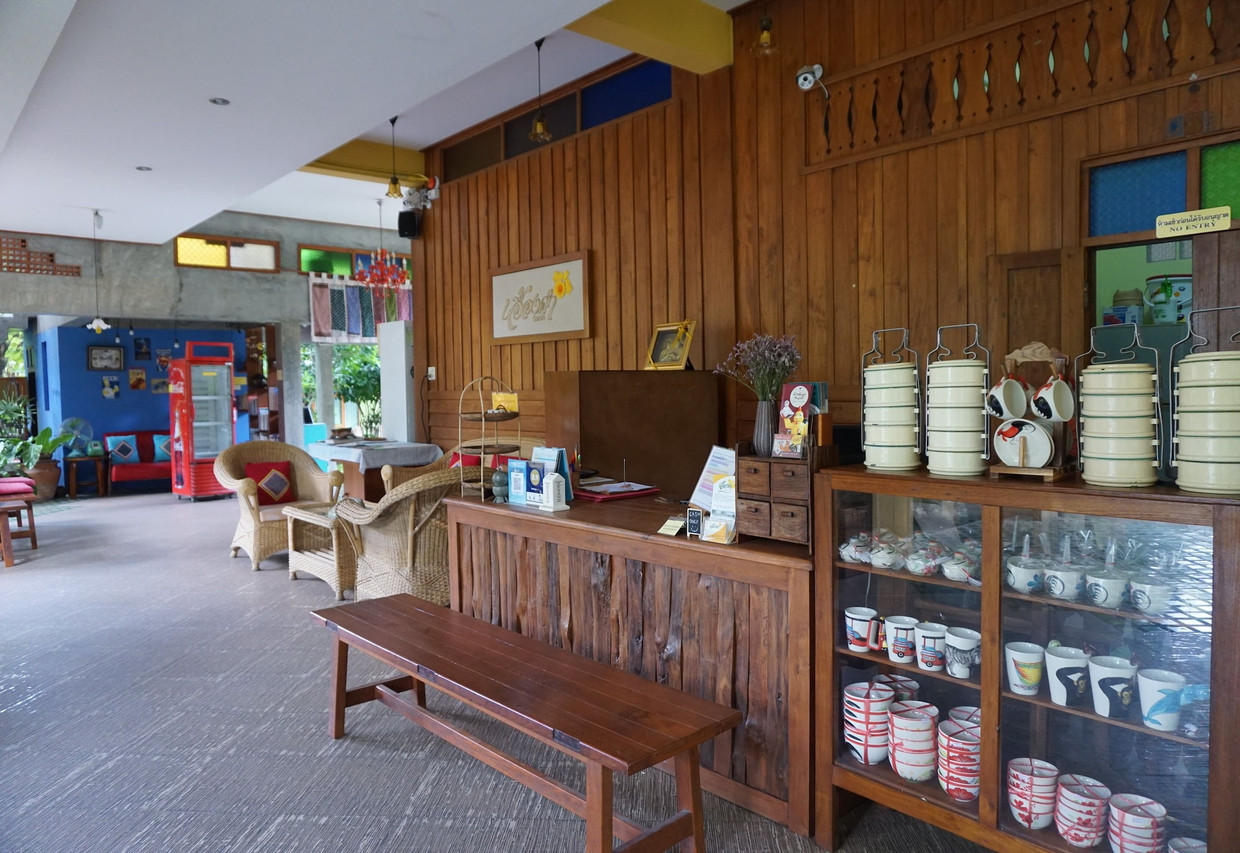 Reception corner decorated with vintage tiffin carriers and traditional Thai pieces