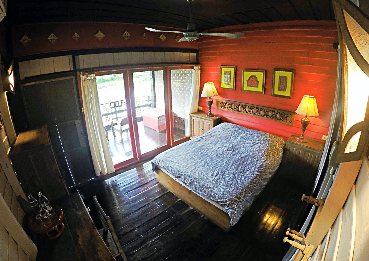 Red-walled room with a private balcony overlooking the Wang River