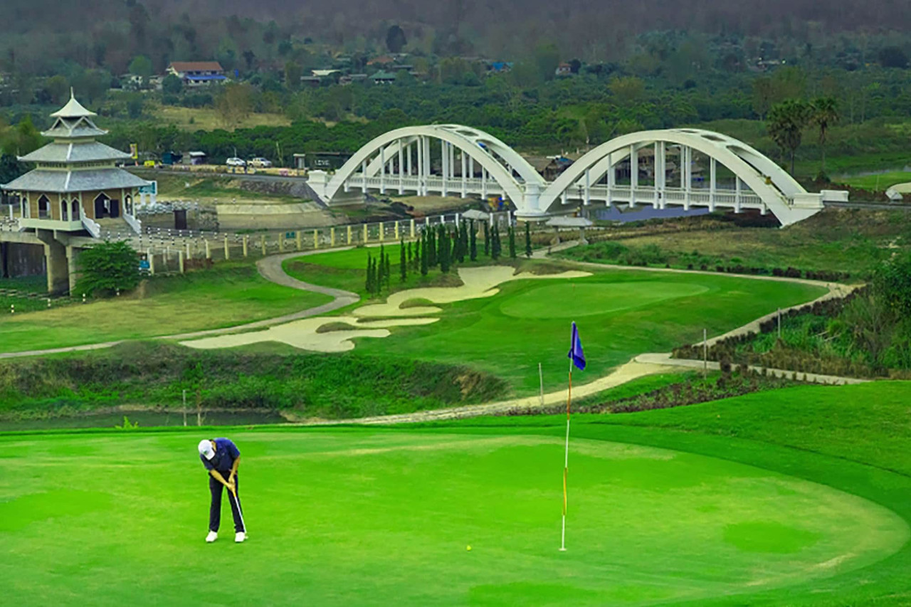 Golf green with the white bridge replica of the Khuntan railway bridge at Gassan Khuntan