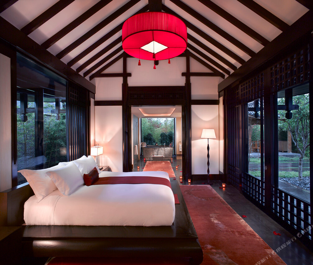 A Naxi-style courtyard villa with a curved-roof pavilion at dusk at Banyan Tree Lijiang