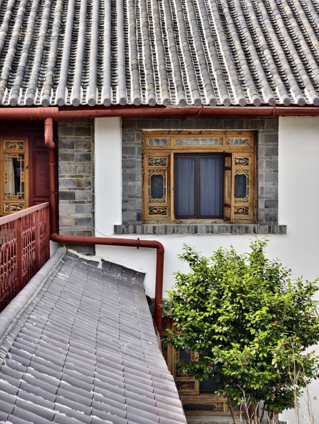 Wangfu Hotel Lijiang (丽江王府饭店) — หน้าโรงแรมเรือนไม้แดง-ทองสไตล์นาซี ป้ายแกะสลัก WANG FU HOTEL OF LIJIANG พร้อมรถลากไฟฟ้าของเมืองเก่า