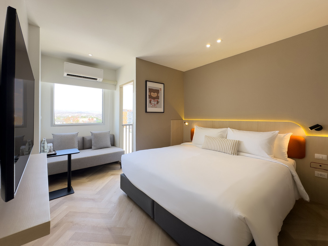 ห้อง Superior King ของ Fortune D Hotel Loei เตียงใหญ่ โซฟา ระเบียงวิวภูเขา