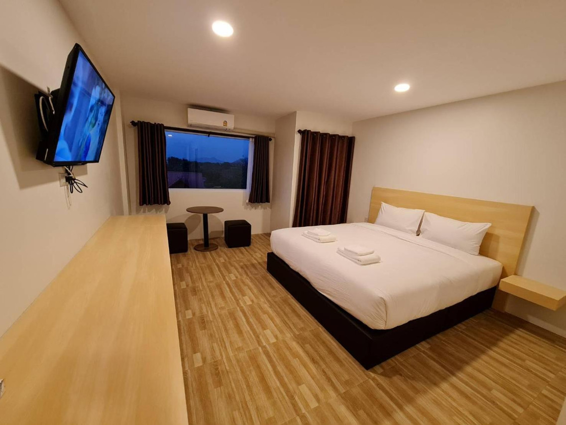 ห้อง King เตียงใหญ่ มุมนั่งเล่นริมหน้าต่าง วิวเขายามเย็น The Charlotte Smart Hotel Lopburi