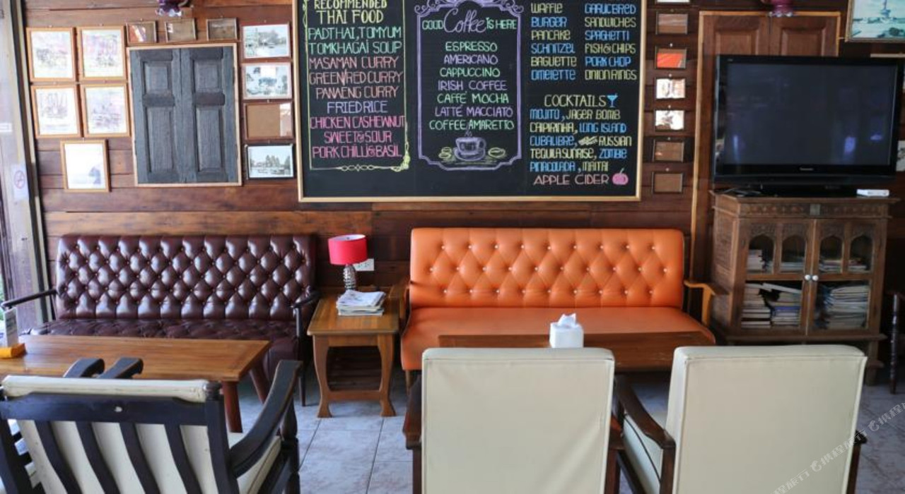 Lounge and on-site restaurant with a wooden wall, chalkboard menu, and framed Lopburi photos