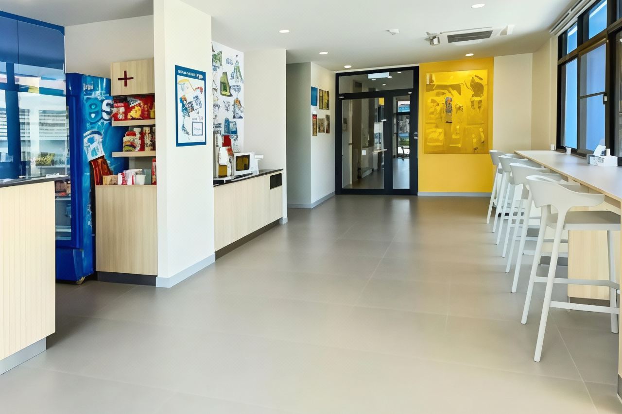Ground-floor common area at Hop Inn with a snack fridge, microwave and white bar-stool seating