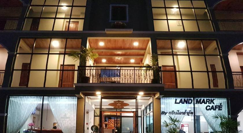ตึกโรงแรมตอนกลางคืนพร้อมป้าย Landmark Café ที่ทางเข้า